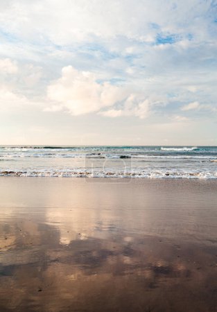 Photo for Vertical photo of empty and calm beach with ocean on background at sunset. - Royalty Free Image