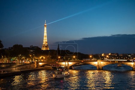 PARIS, Francja - 15 sierpnia 2022: Podświetlany most Pont Des Invalides Over River Seine z przewodnikiem i widokiem na Wieżę Eiffla w nocy w Paryżu, Francja