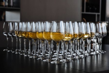 A lot of wine glasses with a cool delicious champagne at the bar. Alcohol background. Party and holiday celebration concept