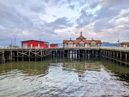 Photo for Buildings on the Victorian Pier at Dunoon, Argyll, Scotland, with reflections and a cloudy sky - Royalty Free Image