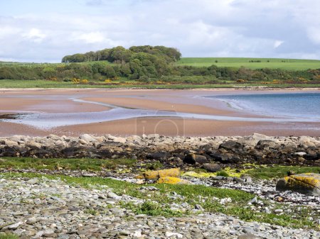 View over the sandy beach at Scalpsie Bay on the Isle of Bute, Scotland, at low tide