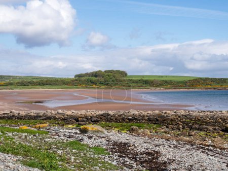 View over the sandy beach at Scalpsie Bay on the Isle of Bute, Scotland, at low tide