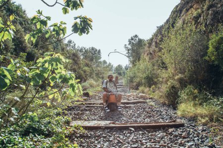 Téléchargez les photos : Voyageur fou jouant au milieu des voies ferrées abandonnées - en image libre de droit