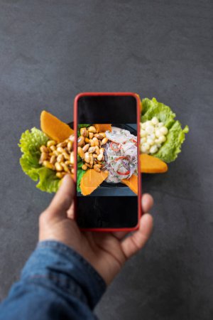 Téléchargez les photos : L'homme prend une photo sur son smartphone plat de ceviche péruvien de poisson mariné, blog alimentaire. - en image libre de droit