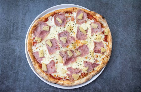 Delicious Hawaiian-style pizza on a rustic background. top view
