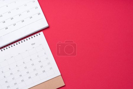Nahaufnahme des Kalenders auf rotem Tischhintergrund, Planung für Geschäftstreffen oder Reiseplanungskonzept