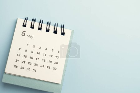 Nahaufnahme des Kalenders auf dem blauen Tischhintergrund, Planung für Geschäftstreffen oder Reiseplanungskonzept