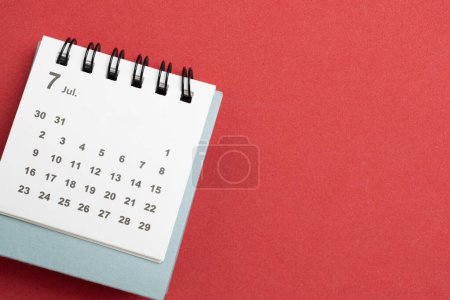 Photo for Close up of calendar on the red table background, planning for business meeting or travel planning concept - Royalty Free Image