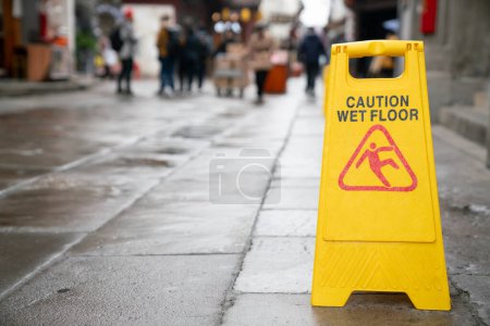 Téléchargez les photos : Fermer le panneau d'avertissement pour la prudence sol mouillé - en image libre de droit