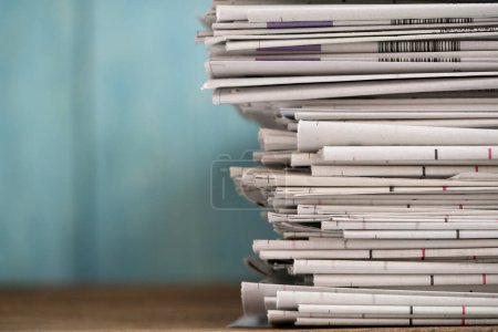 close up newspapers folded and stacked background on the table with green background.