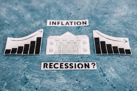 Photo for Inflation and recession texts with bank icon in between graphs with stats going up then going down, concept of economic struggles after the pandemic - Royalty Free Image