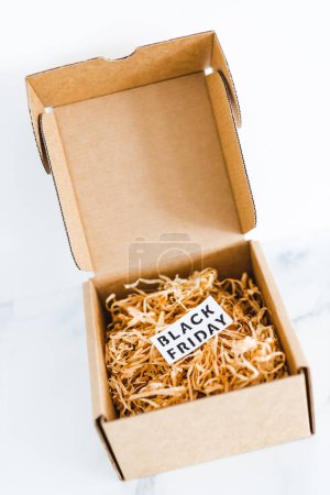 Foto de Promociones y ofertas de compras durante la temporada festiva, paquete o caja de regalo con etiqueta de Viernes Negro dentro de ella - Imagen libre de derechos
