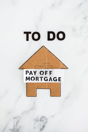 Téléchargez les photos : To Do Pay Off Mortgage text with cardboard house, concept of financial independence and being free from debt - en image libre de droit