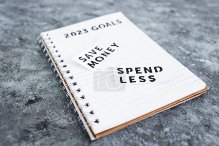 Téléchargez les photos : Save money and spend less on 2023 goals notebook, concept of financial stability and being free from debt - en image libre de droit