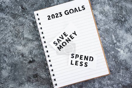 Téléchargez les photos : Save money and spend less on 2023 goals notebook, concept of financial stability and being free from debt - en image libre de droit