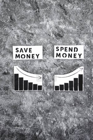 Téléchargez les photos : Save money vs spend money texs side by side with graphs showing wealth going up or down, concept of financial stability and being free from debt - en image libre de droit