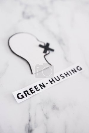 Foto de Green-hushing concept about companies staying silent about their environmental footprints and policies, text and face with  mouth shut - Imagen libre de derechos
