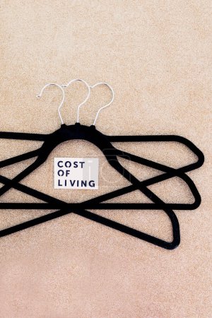 Photo for Shopping and purchasing power in the post pandemic economy, group of clothes hangers with Cost of Living text in the middle concept of buyers reducing their spending - Royalty Free Image
