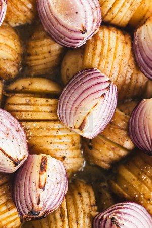 Foto de Patatas hasselback asadas a base de plantas con cebolla en bandeja redonda, recetas de alimentos veganos saludables - Imagen libre de derechos