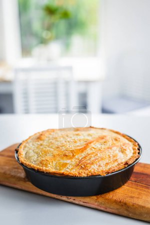 homemade round puff pastry pie in style of a sheperd's pie with sesame seeds topping just out of the oven, healthy food recipes