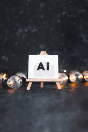 Texto AI sobre lienzo sobre caballete con bombillas a su alrededor, concepto de arte y aprendizaje automático, imagen NO generada con IA