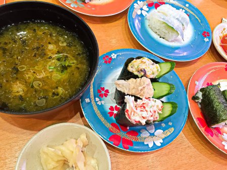 Foto de Cerca en el plato colorido muchas piezas de sushi fresco del restaurante Kaiten-suzhi. - Imagen libre de derechos