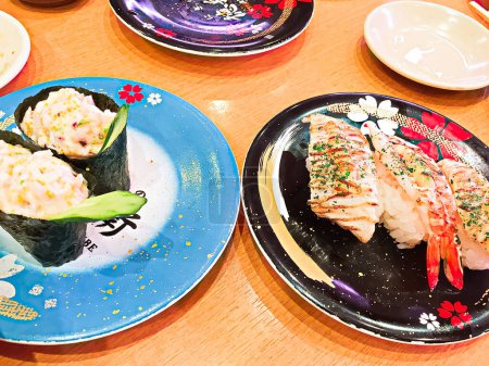 Foto de Cerca en el plato colorido muchas piezas de sushi fresco del restaurante Kaiten-suzhi. - Imagen libre de derechos