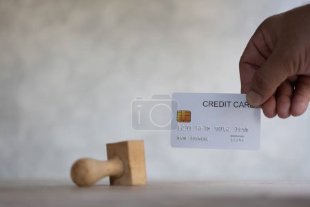 Photo for The concept of apply now credit card from bank. Banking approved  new credit card, customer holding white credit card with wood stamp - Royalty Free Image