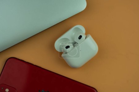 Photo for Bangkok, Thailand - November 15, 2022 : AirPods 3 generations with iPhone 11 and MacBook Pro. Headphones from the apple company. True wireless earphones - Royalty Free Image
