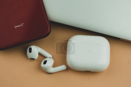 Photo for Bangkok, Thailand - November 21, 2022 : New Apple AirPods 3 with MagSafe Charger and I phone 11 red. Close up - Royalty Free Image