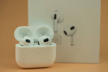 Photo for Bangkok, Thailand - November 28, 2022 : The Charging case next to New Apple Computers AirPods 3 Bluetooth headphones with Active Noise Cancellation for immersive sound - Royalty Free Image