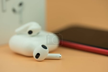 Photo for Bangkok, Thailand - December 14, 2022 : New apple AirPods 3 on a orange background. - Royalty Free Image