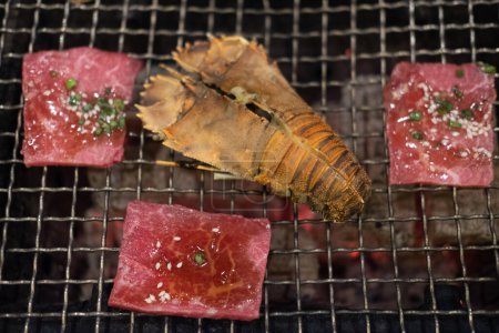 Photo for Cooking big crayfish and raw beef on the grill. Close up - Royalty Free Image