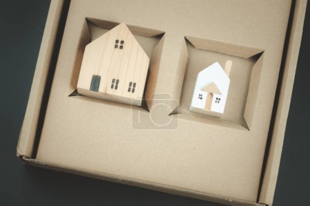 Photo for Small house and big miniature house in hole brown box. family and home concept. Property seller, buyer, agent, offering in selling, buying apartment - Royalty Free Image