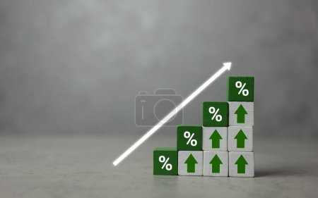 Téléchargez les photos : Cubes en bois vert avec un pourcentage d'icône au-dessus de la flèche pointant vers le haut. La direction d'une flèche symbolisant que les taux d'intérêt sont en hausse. L'économie s'améliore. Espace de copie - en image libre de droit