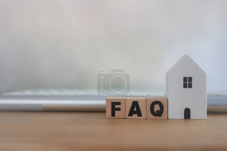 FAQ service d'analyse de la gestion de la clientèle pour concept de maison, service d'assistance et opérateur de centre d'appels. Blocs en bois avec le mot FAQ place avec maison blanche et clavier sur la table
