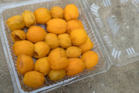 Foto de Maprang cáscara de fruta para listo para comer colocado en una caja de plástico. Características de los huevos ovalados - Imagen libre de derechos