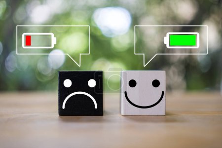 Photo for Happy and angry face on wood block with battery icon in message icon. Negative and positive emotion concepts. The concept of mood, happy workplace - Royalty Free Image