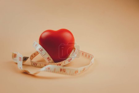 Photo for Red heart surrounded by a tape measure. Healthy concept. - Royalty Free Image