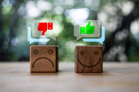 Photo for Wooden cube blocks with unhappy faces with thumbs down and happy faces with thumbs up in speech bubble. Emotional Quotient concept. - Royalty Free Image