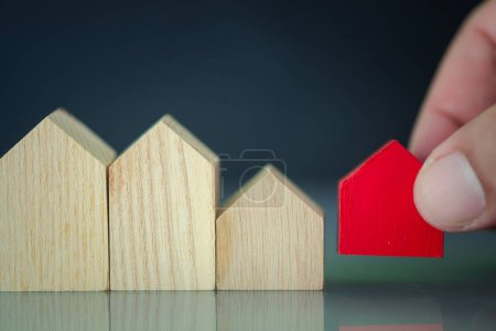 Photo for Hand choosing red miniature house. Chosen house and the best house deal. Planning to buy property. - Royalty Free Image