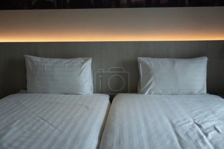 Téléchargez les photos : Deux lits de draps propres et oreiller dans la chambre d'hôtel - en image libre de droit