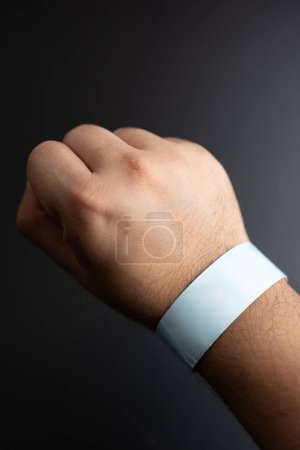 Photo for Blue paper wristband mockup on persons arm. Empty adhesive bangle wristlet sticker on male hand, blue paper bracelet, check tape, event ticket concept - Royalty Free Image