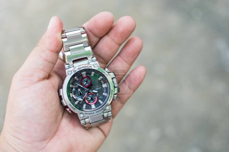 Photo for Samut Prakan, Thailand - February 8, 2024 : A hand holding Casio G-Shock model MTG-B1000D-1ADR, stainless steel wristwatch. G-Shock is a line of watches manufactured by Casio. - Royalty Free Image
