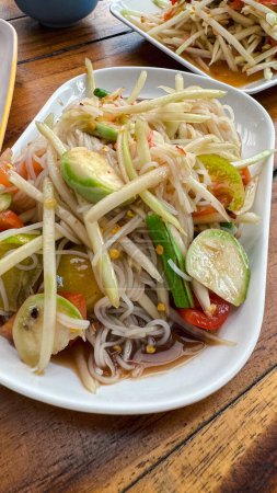 Chinese noodle mix spicy papaya salad it called Tam Sua. Most popular food in Thailand.