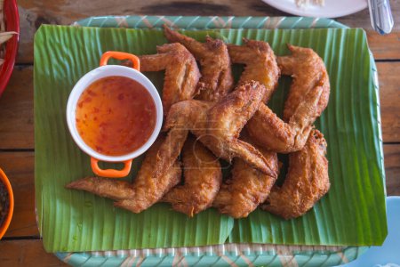 ailes de poulet frit thaïlandais avec sauce sucrée sur feuille de banane