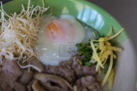 Congee with minced pork, liver, pork entrails and soft boiled in a bowl. Thai rice porridge