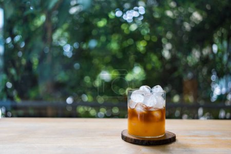 Téléchargez les photos : Jus d'orange avec café noir et mini glaçons ronds en verre sur table en bois, boisson maison - en image libre de droit