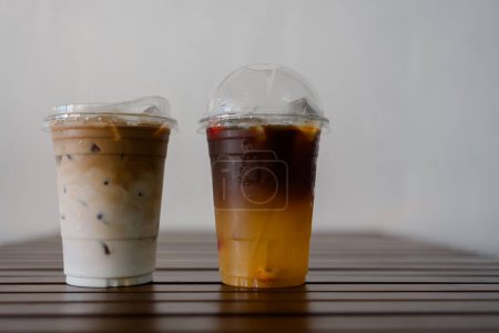 Téléchargez les photos : Café Ice latte et expresso mélangés avec du jus d'orange sur la table - en image libre de droit