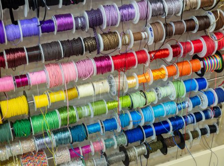 Téléchargez les photos : Des rangées de rubans colorés et des garnitures à bobines dans un magasin d'artisanat. Bricolage, artisanat. - en image libre de droit
